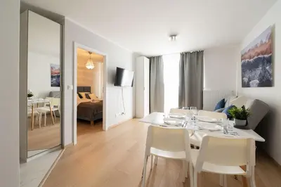 a dining room with a white table and chairs at Sołtysowska Apartment in Kraków