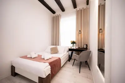 a bedroom with a bed and a desk and a table at Hive Family House in Kraków