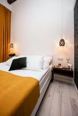 a bedroom with a large bed with a wooden floor at Hive Family House in Kraków