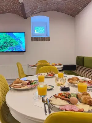 a table with plates of food and orange juice at Hive Family House in Kraków