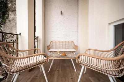 three chairs and a table on a balcony at Hive Family House in Kraków
