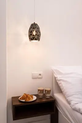 a plate of croissants on a night stand next to a bed at Hive Family House in Kraków