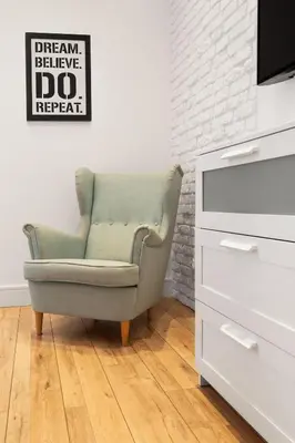 a green chair in a living room next to a dresser at Househost Apartment: Bonerowska 5/19 in Kraków
