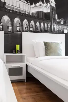 a bedroom with a large white bed with two drawers at Househost Apartment: Bonerowska 5/19 in Kraków