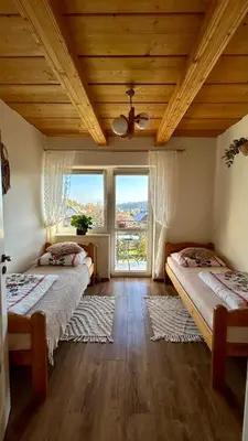 a bedroom with two beds and a large window at Agroturystyka Pod Modrzewiem in Zubrzyca Górna