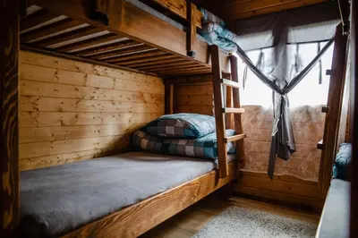 a bunk bed in a log cabin with a window at Domki na Górniej Łące - Dwa Wróble in Łazany