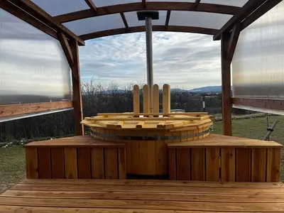 a wooden pergola with two benches on a deck at Domki na Górniej Łące - Dwa Wróble in Łazany