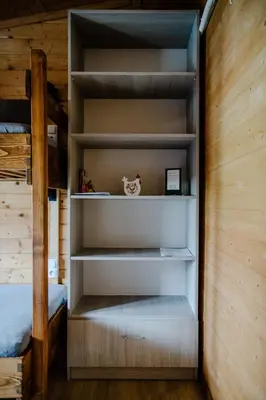 a book shelf in a bedroom with a bunk bed at Domki na Górniej Łące - Dwa Wróble in Łazany
