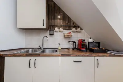 a kitchen with white cabinets and a sink at Apartament Podskalański in Szyce