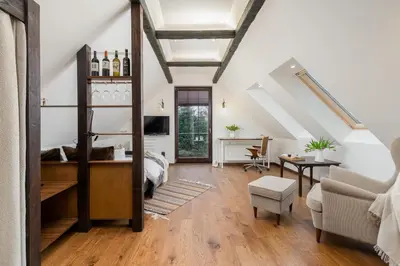 a living room with a bed and a dining room at Apartament Podskalański in Szyce
