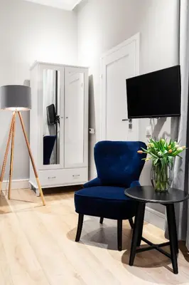 a living room with a blue chair and a table at Househost Apartment: Bonerowska 5/15 in Kraków