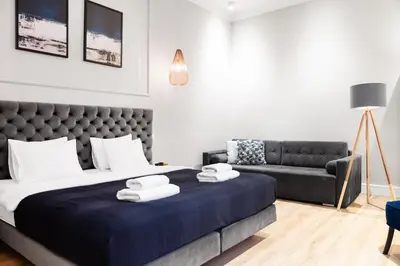 a bedroom with a large bed and a couch at Househost Apartment: Bonerowska 5/15 in Kraków