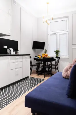 a kitchen and dining room with white cabinets and a table at Househost Apartment: Bonerowska 5/15 in Kraków