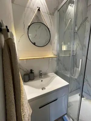a bathroom with a sink and a mirror and a shower at Przyszowa 441 in Przyszowa