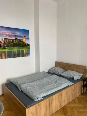 a bed in a room with a painting on the wall at Best View Old Town Rooms in Kraków