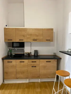 a kitchen with wooden cabinets and a counter top at Best View Old Town Rooms in Kraków