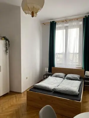 a bedroom with a bed and a large window at Best View Old Town Rooms in Kraków