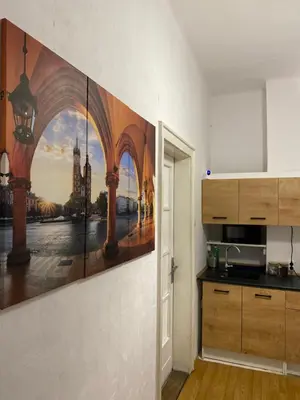 a kitchen with a painting on the wall at Best View Old Town Rooms in Kraków