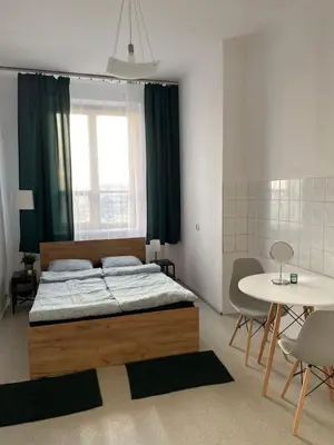 a bedroom with a bed and a table with chairs at Best View Old Town Rooms in Kraków