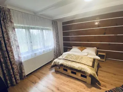 a bedroom with a wooden headboard and a bed at Na Łachówce in Skawa