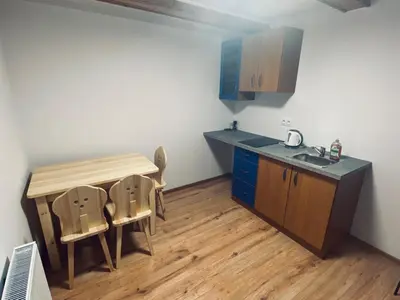 a kitchen with a table and chairs and a sink at Na Łachówce in Skawa