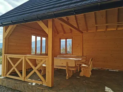 a large wooden cabin with a table in it at Predlówka - Na dachu Świata in Zawoja