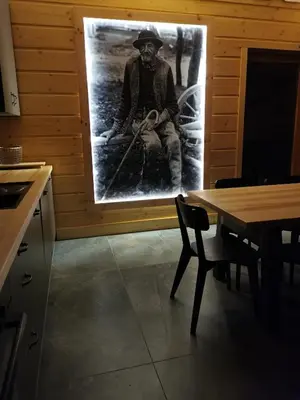 a picture of a man sitting on a bench in a kitchen at Predlówka - Na dachu Świata in Zawoja