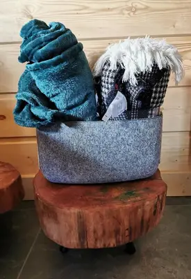 a blanket in a basket on a wooden table at Predlówka - Na dachu Świata in Zawoja