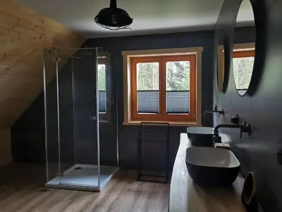 a bathroom with a glass shower and a sink at Predlówka - Na dachu Świata in Zawoja