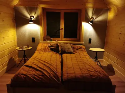 a bedroom with a large bed with two tables at Predlówka - Na dachu Świata in Zawoja