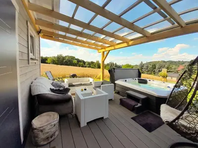 a patio with a jacuzzi tub on a deck at Słodki Zakątek Spa Jacuzzi&Sauna in Sobolów
