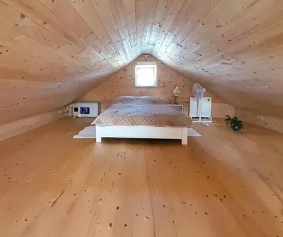 a large bedroom with a bed in a wooden ceiling at Słodki Zakątek Spa Jacuzzi&Sauna in Sobolów
