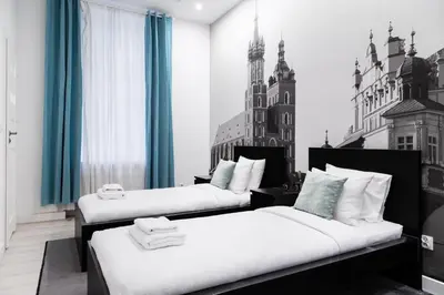 two beds in a room with buildings on the wall at Househost Apartment: Bonerowska 5/11 in Kraków
