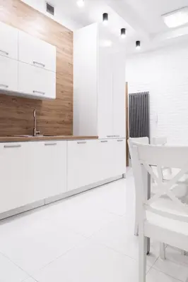 a kitchen with white cabinets and a white chair at Househost Apartment: Bonerowska 5/11 in Kraków