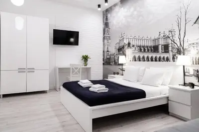 a white bedroom with a bed with towels on it at Househost Apartment: Bonerowska 5/11 in Kraków