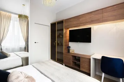 a bedroom with a bed and a desk and a tv at Blue Residence Orawska 5 in Kraków