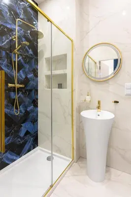 a bathroom with a shower and a sink and a mirror at Blue Residence Orawska 5 in Kraków