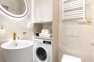 a bathroom with a washing machine and a sink at Blue Residence Orawska 5 in Kraków