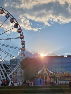 a ferris wheel at a carnival with the sunset in the background at Blue Residence Orawska 5 in Kraków