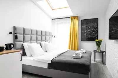 a bedroom with a large bed and a window at HOUSEHOST Apartament: ul. Miodowa 42/42a in Kraków