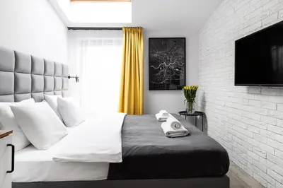 a bedroom with a bed with two towels on it at HOUSEHOST Apartament: ul. Miodowa 42/42a in Kraków
