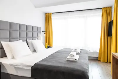 a bedroom with a large bed with towels on it at HOUSEHOST Apartament: ul. Miodowa 42/42b in Kraków