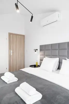 a bedroom with a large white bed with two white towels at HOUSEHOST Apartament: ul. Miodowa 42/42b in Kraków