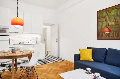 a living room with a blue couch and a table at HOUSEHOST Apartment :Starowiślna 66/9 Street in Kraków