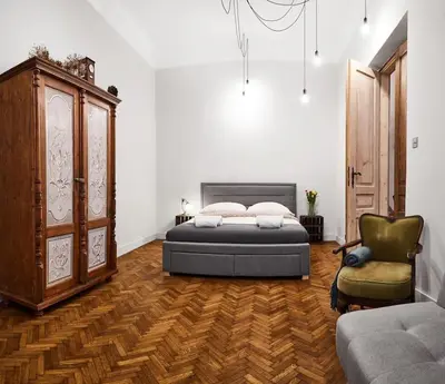 a bedroom with a bed and a chair at HOUSEHOST Apartment: Józefa Dietla 73/7 in Kraków