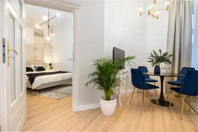 a living room with a table and chairs and a bedroom at HOUSEHOST Apartment: Starowiślna Street 36/27 in Kraków