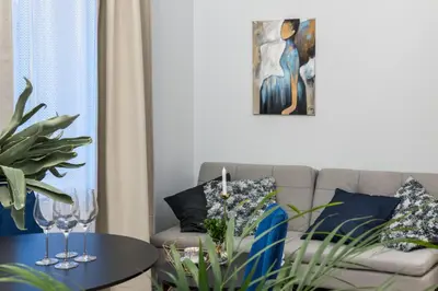 a living room with a couch and a table with wine glasses at HOUSEHOST Apartment: Starowiślna Street 36/27 in Kraków