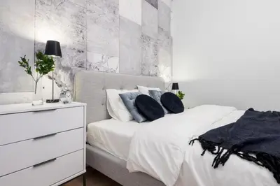 a bedroom with a white bed with blue pillows at HOUSEHOST Apartment: Starowiślna Street 36/27 in Kraków