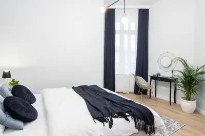 a bedroom with a bed with black pillows on it at HOUSEHOST Apartment: Starowiślna Street 36/27 in Kraków