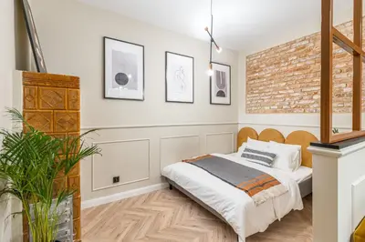 a bedroom with a bed and a brick wall at HOUSEHOST Apartment : Topolowa 26/17 in Kraków